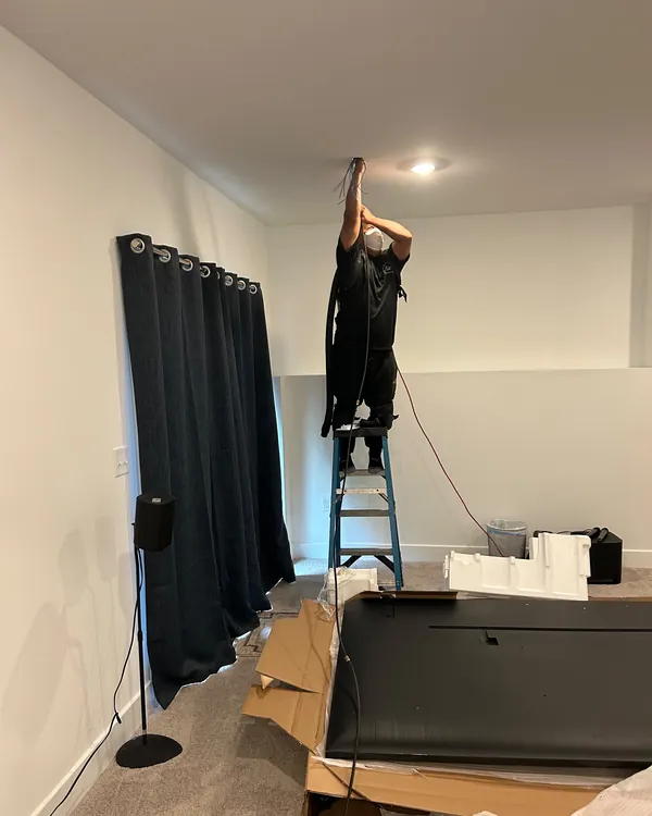 Technician on a stepladder cleaning a ceiling air vent
